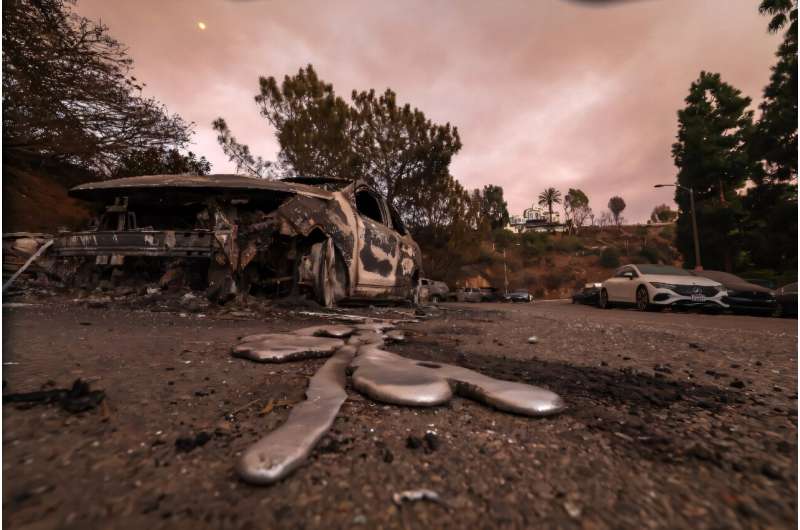 Molten metal flows from a car burnt out by the Palisades Fire in Los Angeles, California