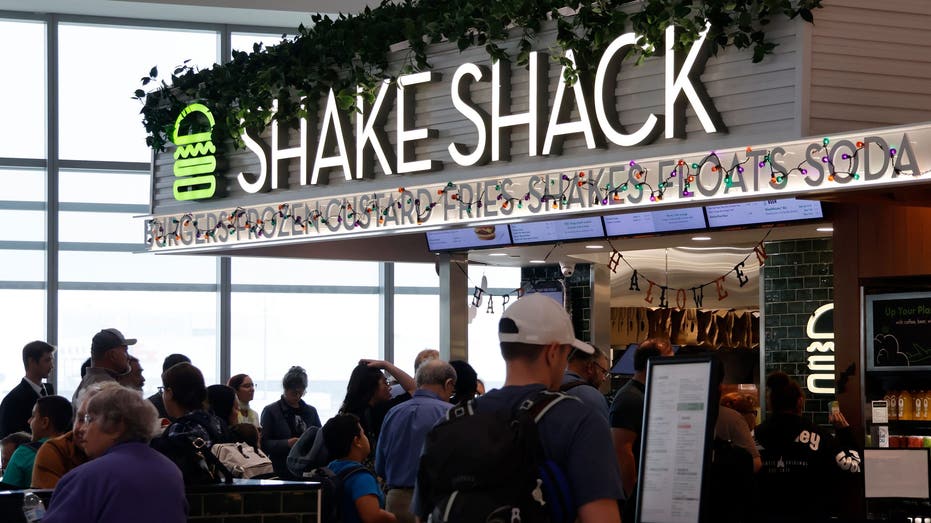 NEWARK, NJ - SEPTEMBER 28: Travelers eat at a Shake Shack restaurant in Terminal A at Newark Liberty International Airport on September 28, 2024, in Newark, New Jersey. (Photo by Gary Hershorn/Getty Images)