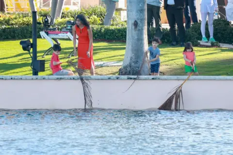 Getty Images Woman and three kids look over waterway