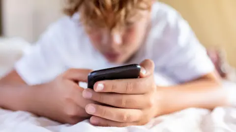 Getty Images A child using a mobile phone
