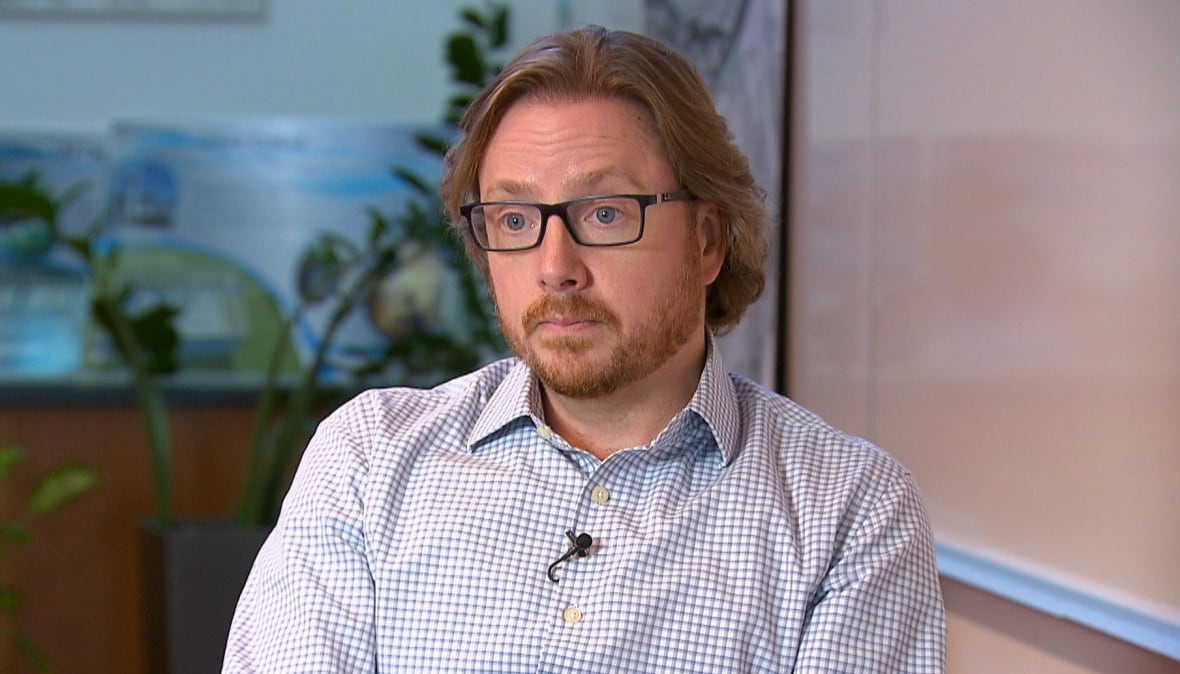 A portrait of of a man with a beard and glasses. 