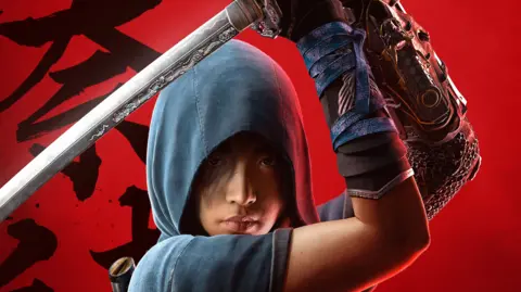 Ubisoft Screenshot shows a hooded woman with a katana raised above her head. She holds the blade in both hands, each clad in an elaborate leather gauntlet. Behind her is a blood-red backdrop with flashes of black Japanese calligraphy.