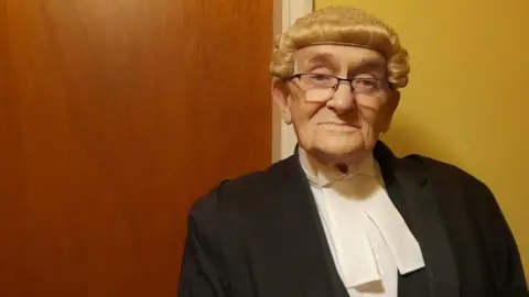 Noel Philo Noel Philo dressed is his barrister attire, including wig and gown.