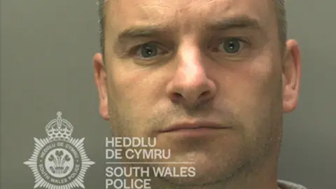 South Wales Police Christopher Cooper mugshot. He has grey short hair. 