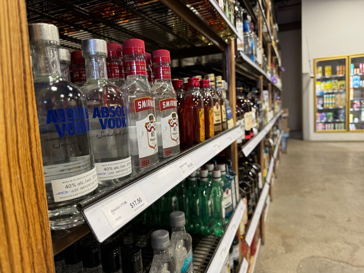 A view of liquor bottles on a store shelf, with vodka in the foreground.