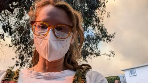 BBC A young women in glasses wearing a mask to protect herself from smoke