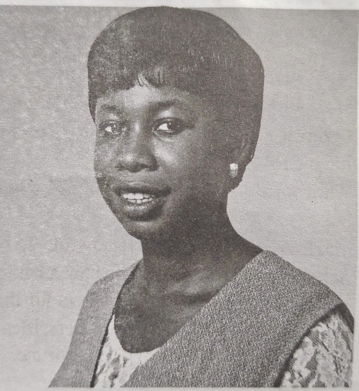 A woman poses for a headshot in a dated photo.