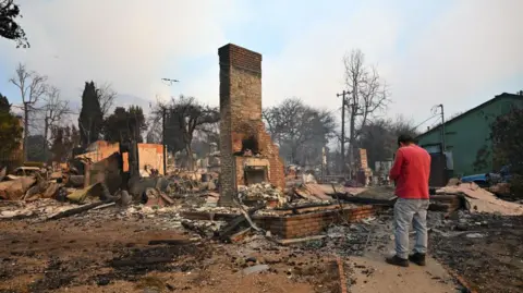 Getty Images A home in Altadena is reduced to its chimney after being destroyed by the Eaton fire. 