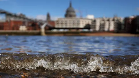 EPA Small wave on River Thames in foreground with St Paul's out of focus in background