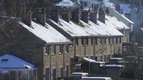 Getty Images A row of terraced houses with chimneys on a frosty winter's day.