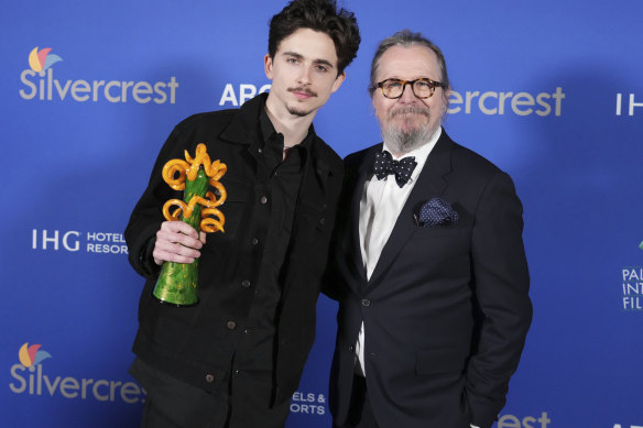 Timothee Chalamet, with the chairman’s award for A Complete Unknown, and Gary Oldman pose in the press room.