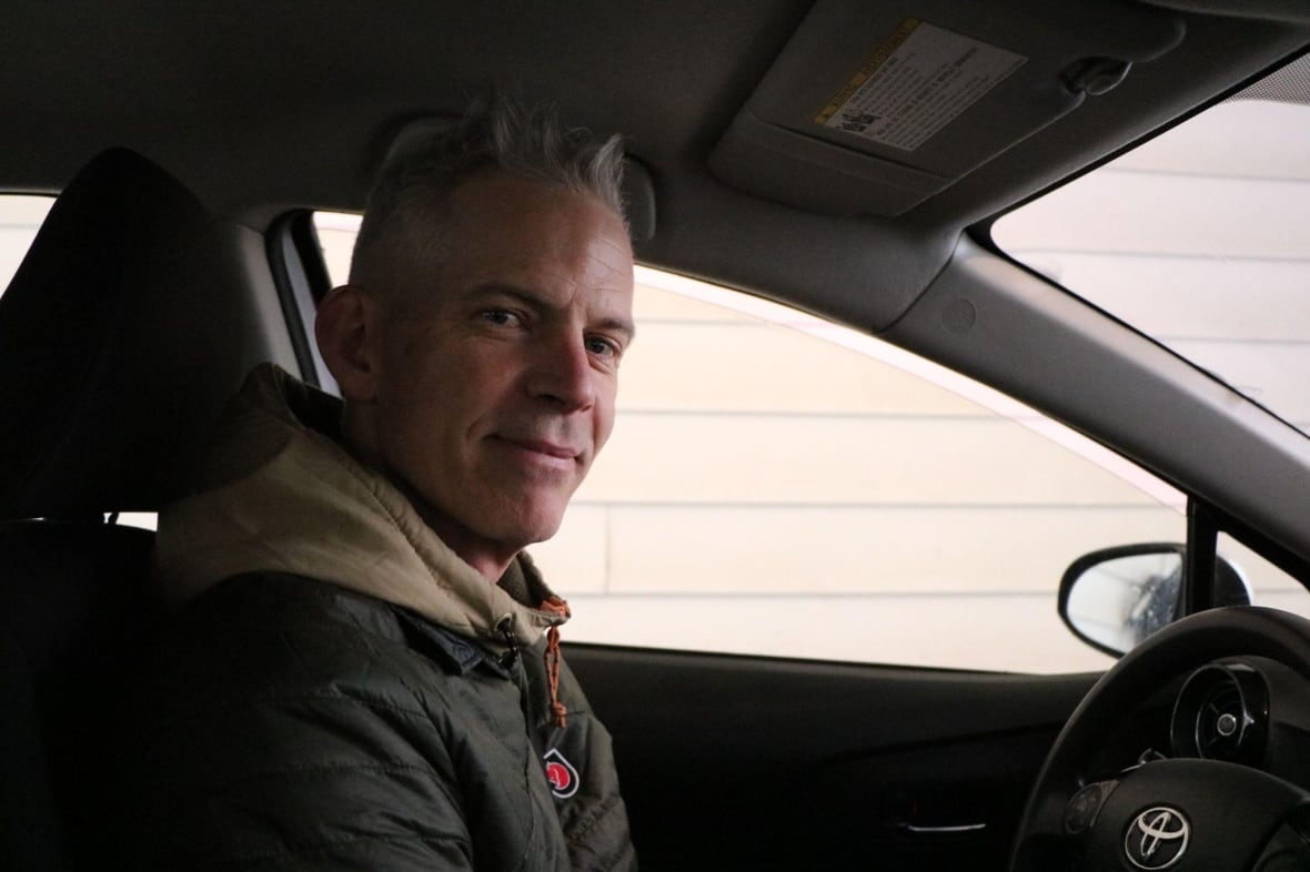 A man sitting in his car. 