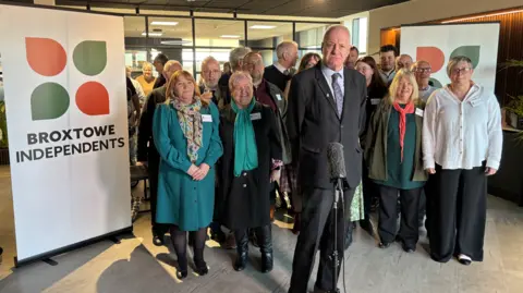 BBC A group of Broxtowe Borough Councillors standing next to a sign that says 'Broxtowe Independents'